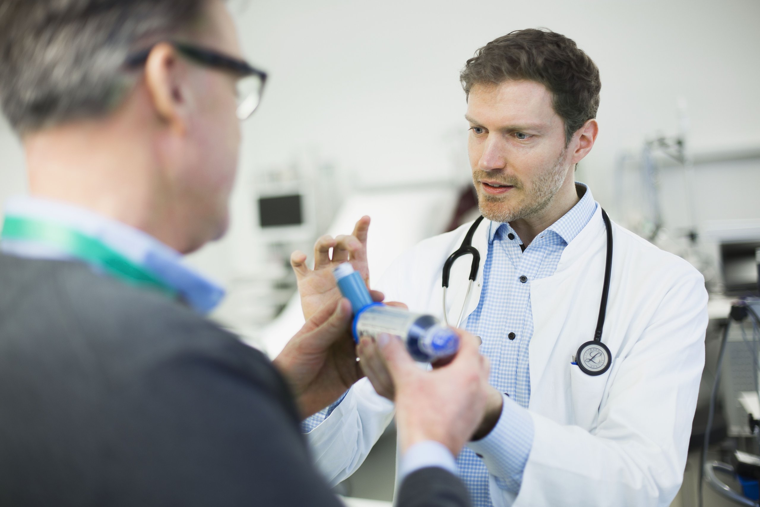 Arzt erklärt einem Probanden die Nutzung eines Inhalators